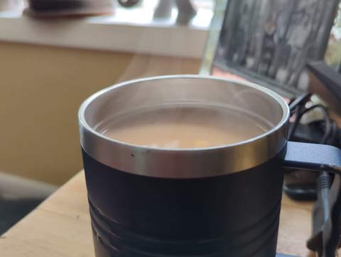 video showing steam rising from a cup of coffee on a cold morning
