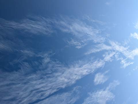 A blue sky with feathered clouds stretching acoss from left to right