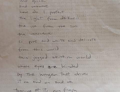 Close up of a part of a poem written in longhand on the back of a page containing the guitar tabs for the song Anarchy in the UK by the Sex Pistols